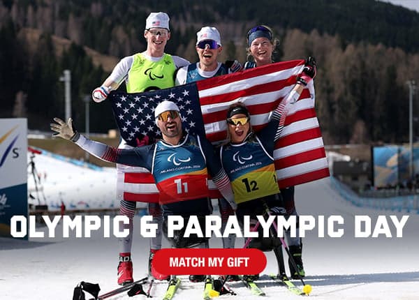 Team USA Winter paralympic team members celebrate with the flag.