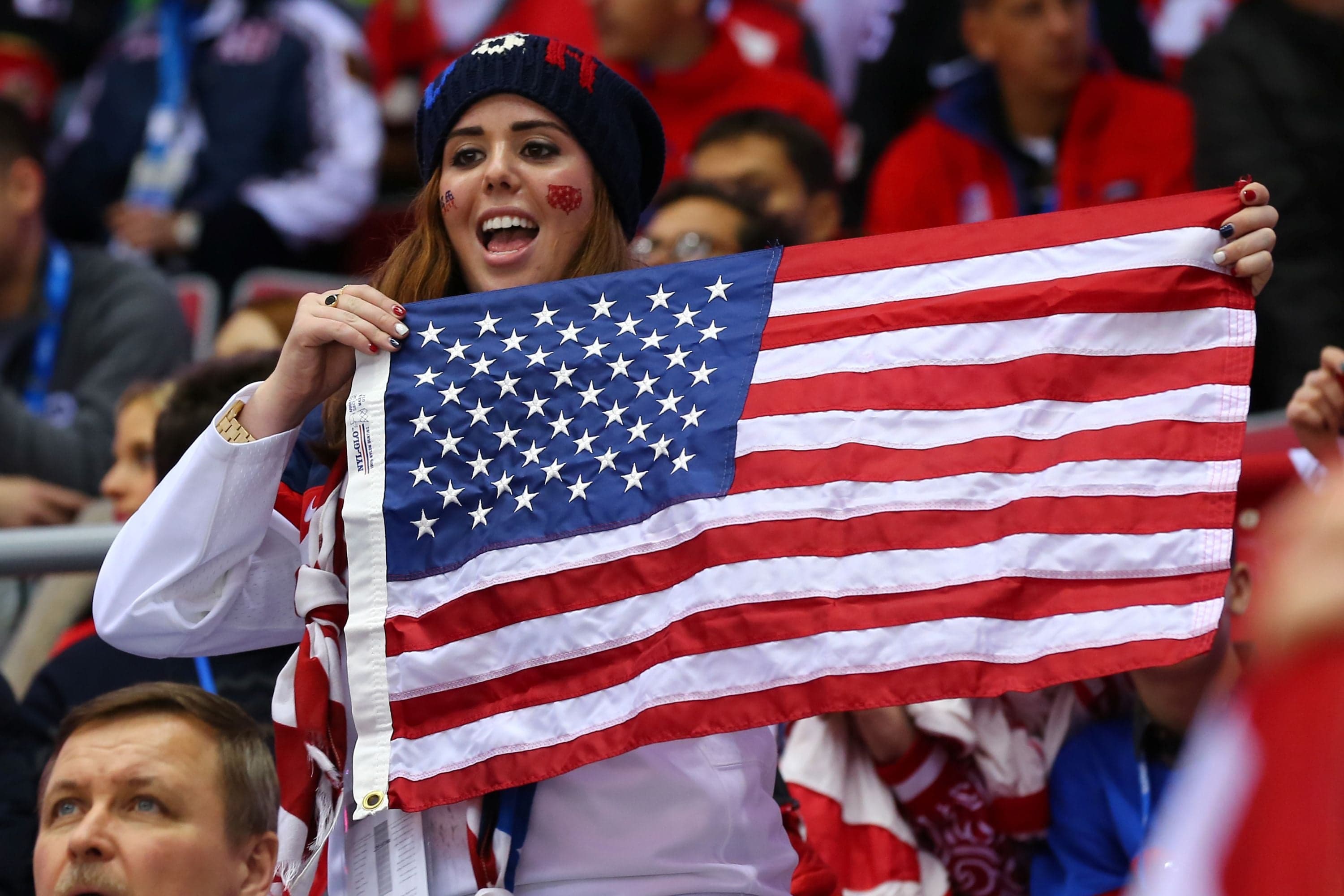 Team USA fan celebrates with the U. S. flag.